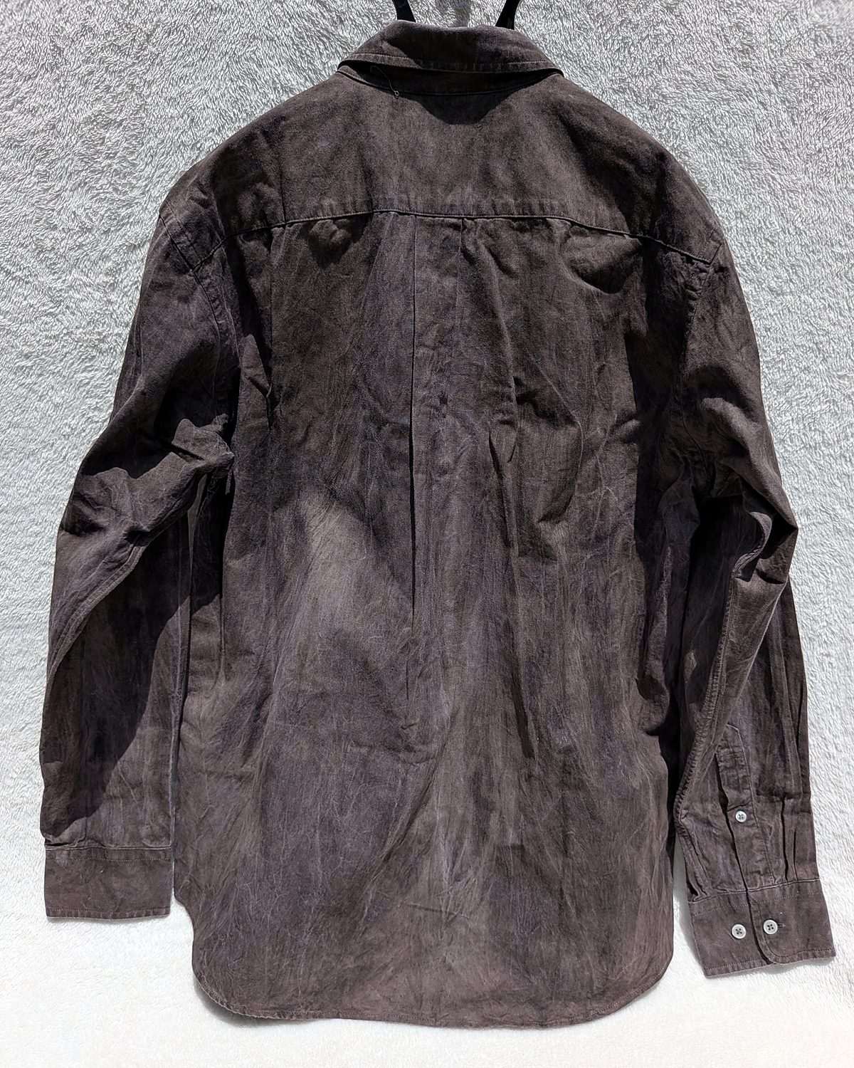 Kakishibu-dyed button-down shirt hanging in the sun, seen from the back